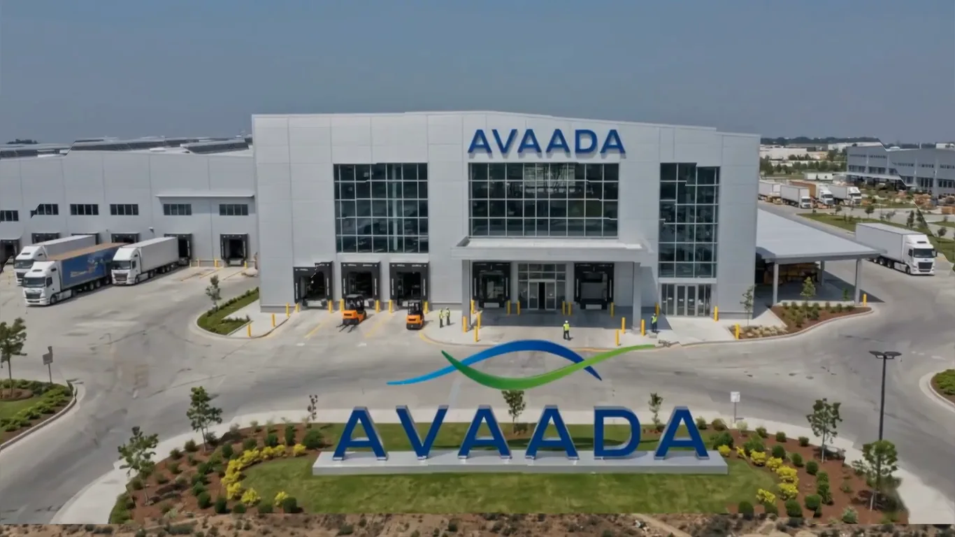 Avaada factory facade with AVAADA signage, entrance logo monument and trucks at the loading docks